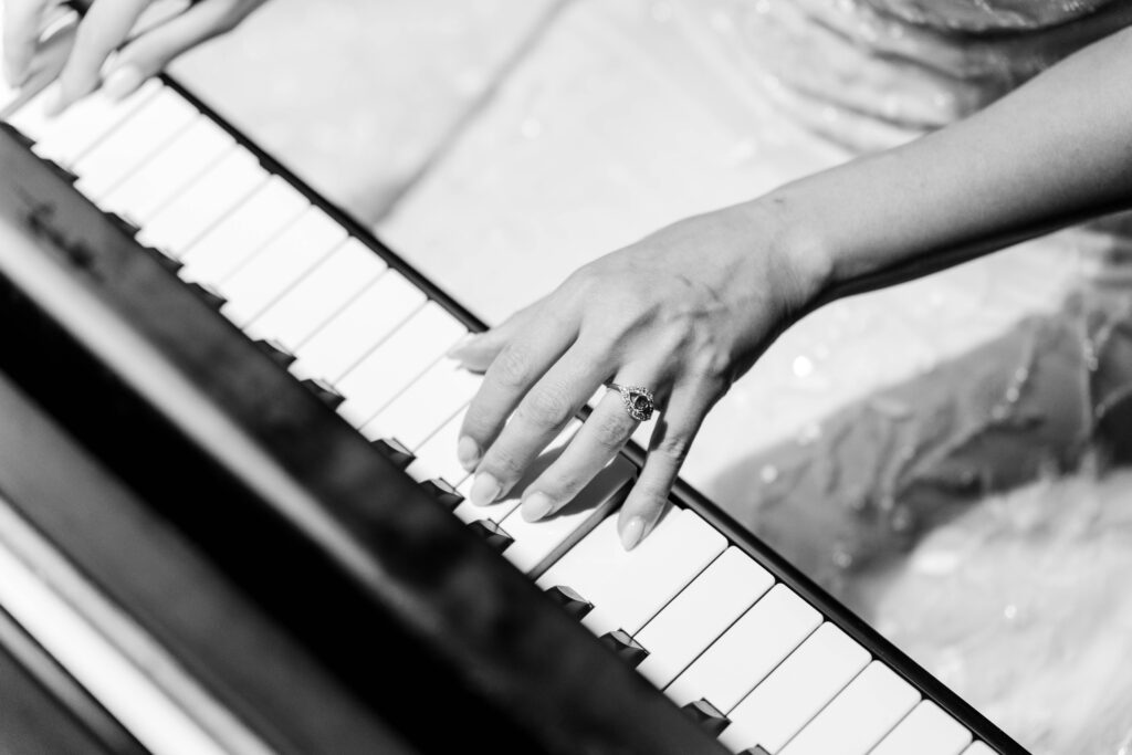 Sertap playing piano as she wears the custom ring Max made for her.