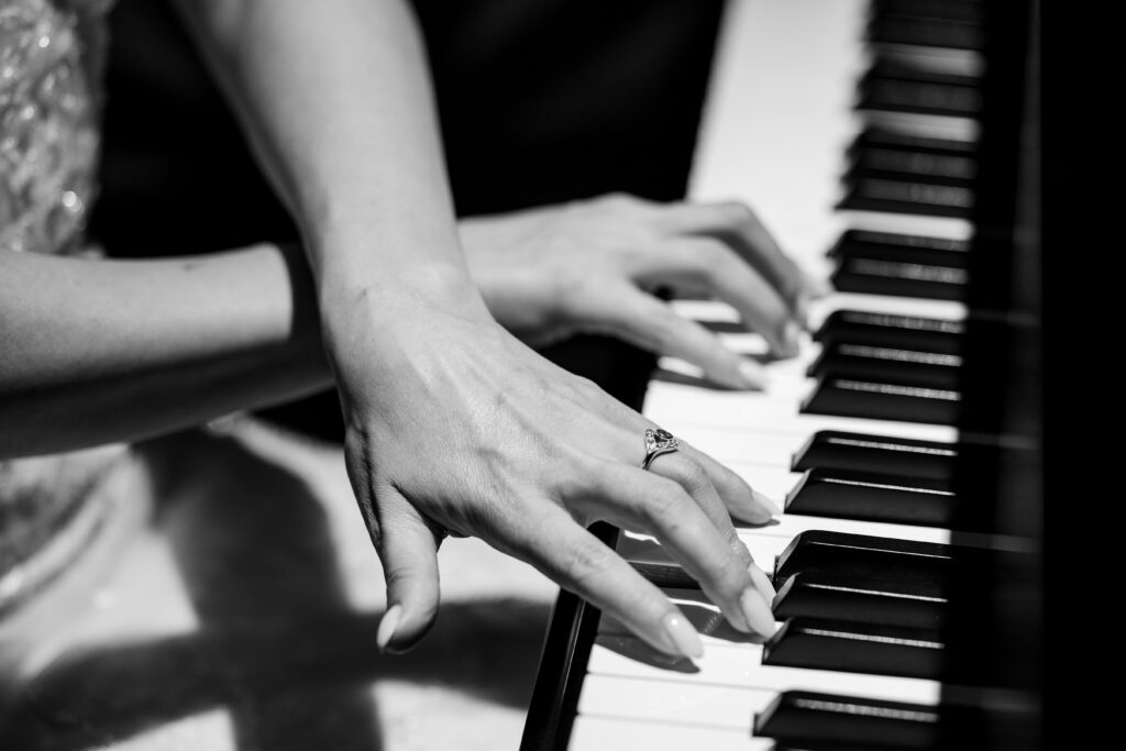 Sertap playing piano as she wears the custom ring Max made for her.
