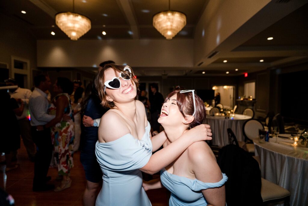 Bridesmaids having a great time wearing glasses, drinking and dancing!