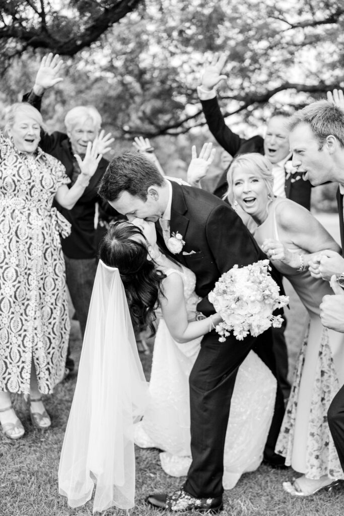 Bride and groom kissing and family cheering at Blythefield